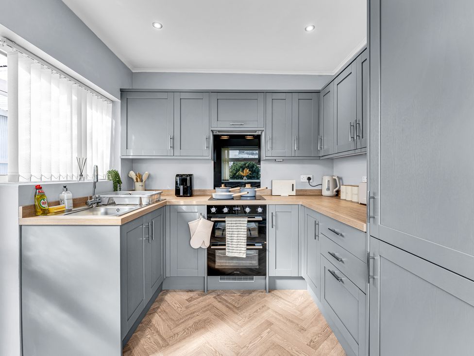 A kitchen with cabinets and appliances at Mallory House in Stoke-on-Trent