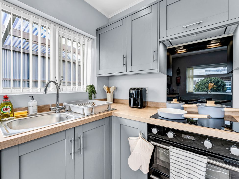 A kitchen with sink and stove at Mallory House in Stoke-on-Trent