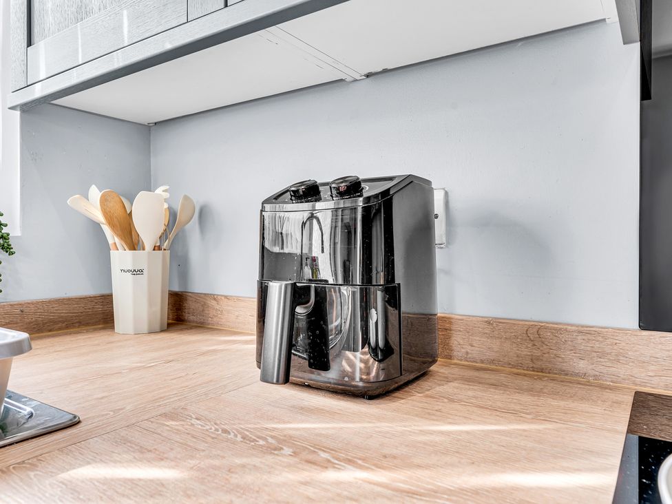 A kitchen with an air fryer and utensil holder at Mallory House Stoke-on-Trent