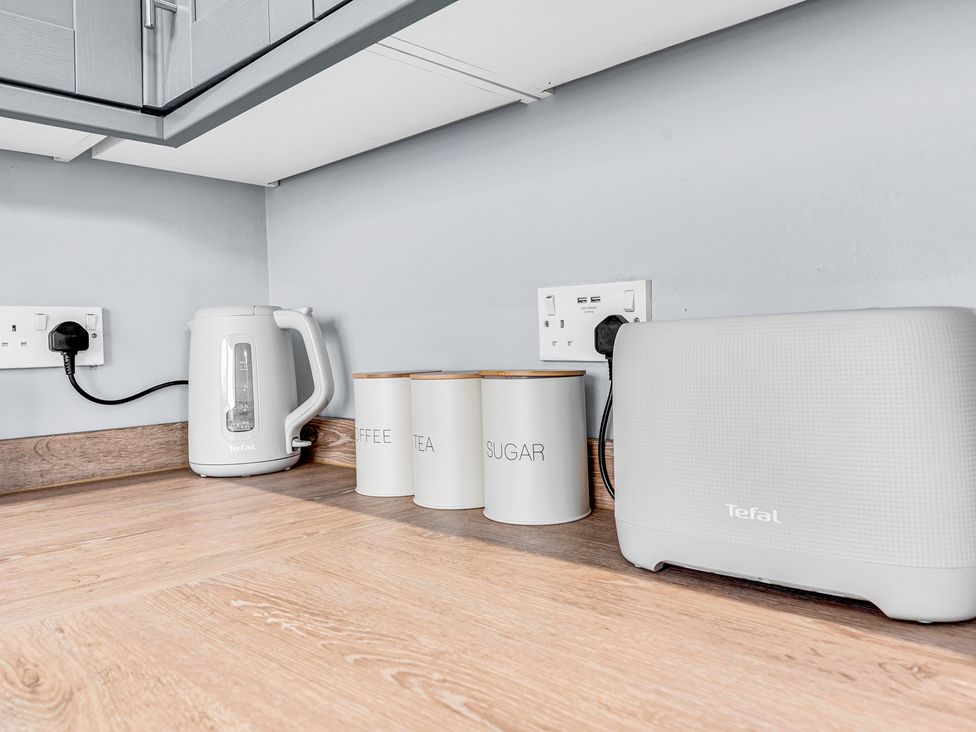 A kitchen countertop with a kettle, canisters, and a speaker at Mallory House in Stoke-on-Trent
