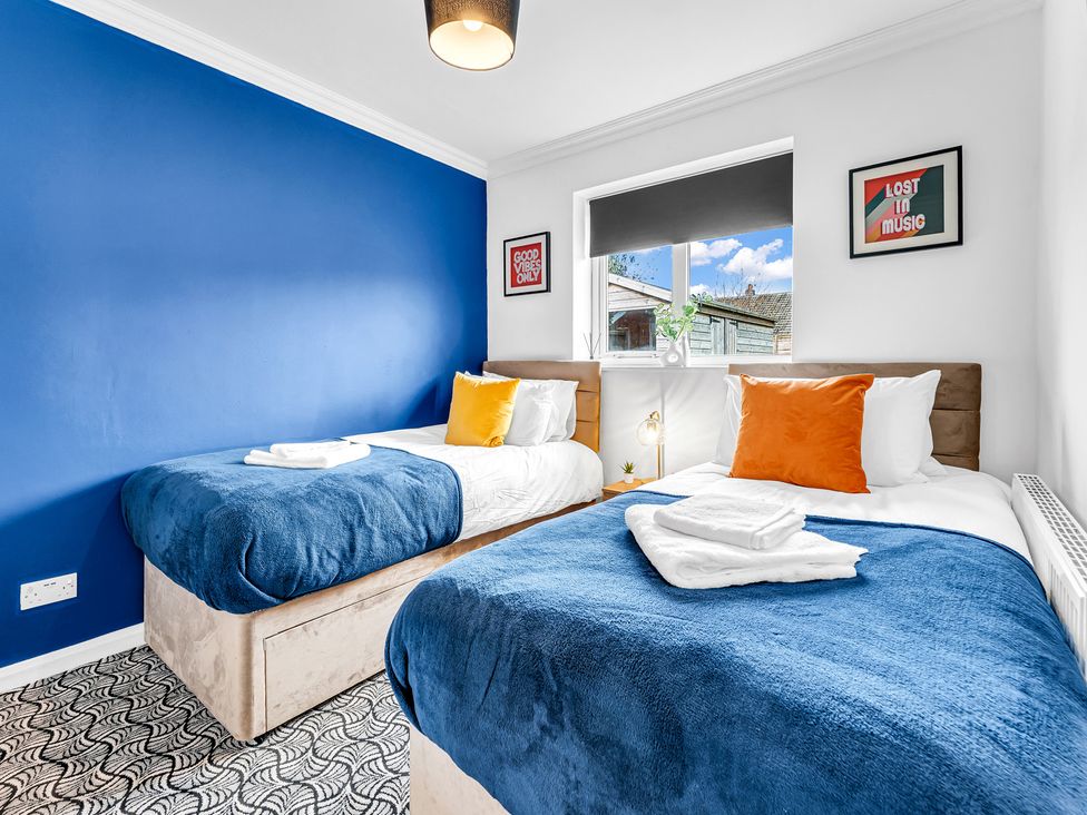 A bedroom with two beds and posters on the wall at Mallory House in Stoke-on-Trent