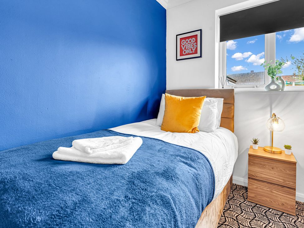 A bedroom with a bed and nightstand at Mallory House in Stoke-on-Trent