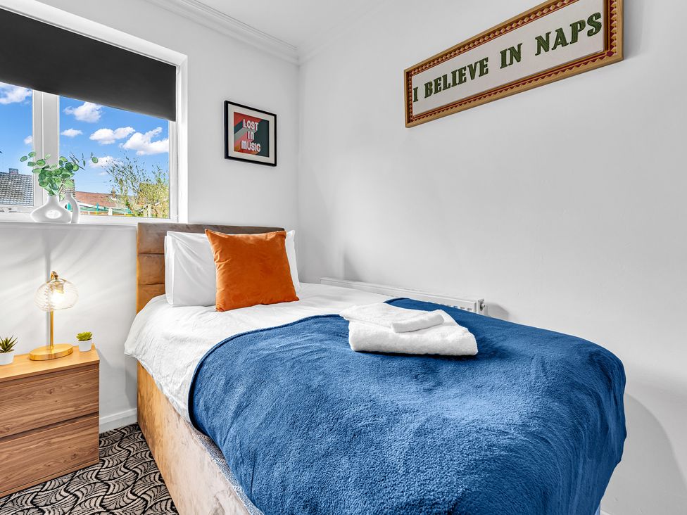 A bedroom with a single bed and a nightstand at Mallory House in Stoke-on-Trent