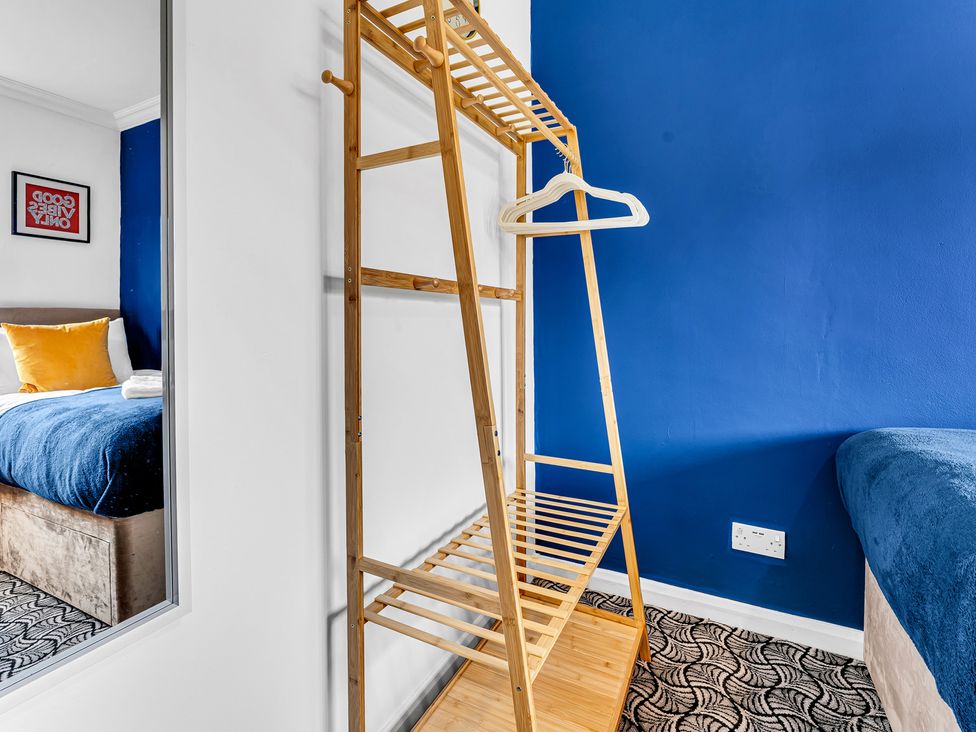 A bedroom with a clothes rack and a bed at Mallory House in Stoke-on-Trent