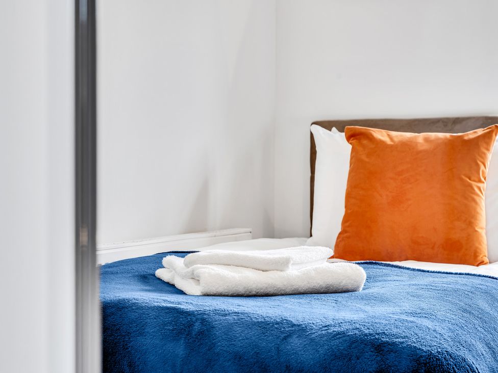 A bed with towels and pillows at Mallory House in Stoke-on-Trent