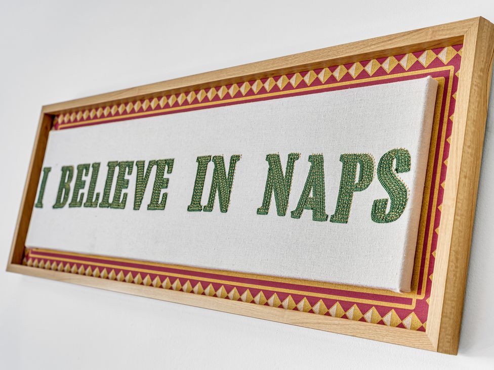 A framed art piece with the text I BELIEVE IN NAPS at Mallory House in Stoke-on-Trent