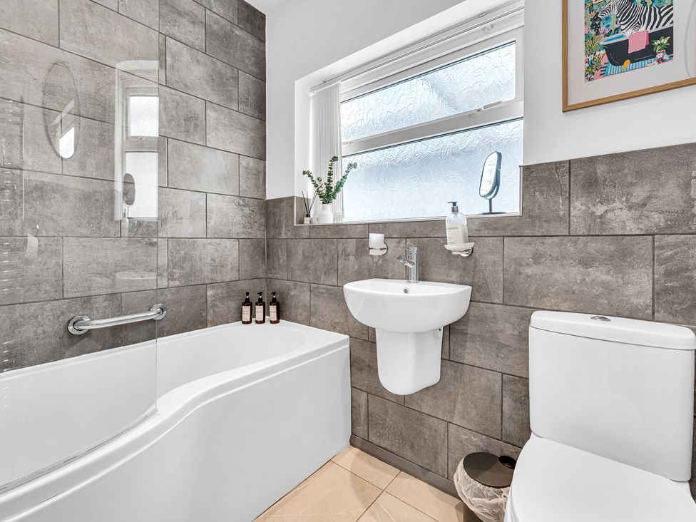 A bathroom with a bathtub and sink at Mallory House Stoke-on-Trent