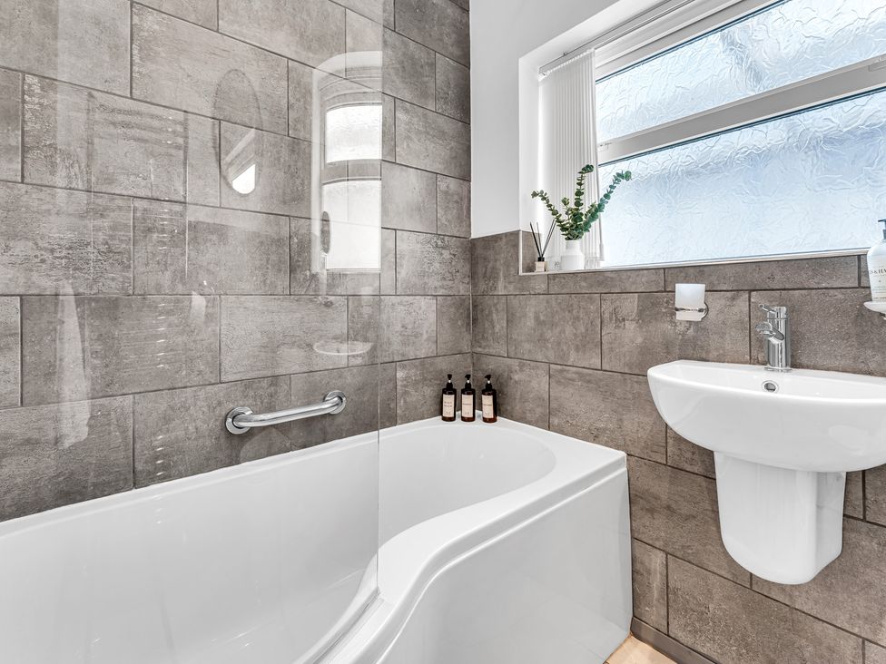 A bathroom with a bathtub and sink at Mallory House in Stoke-on-Trent