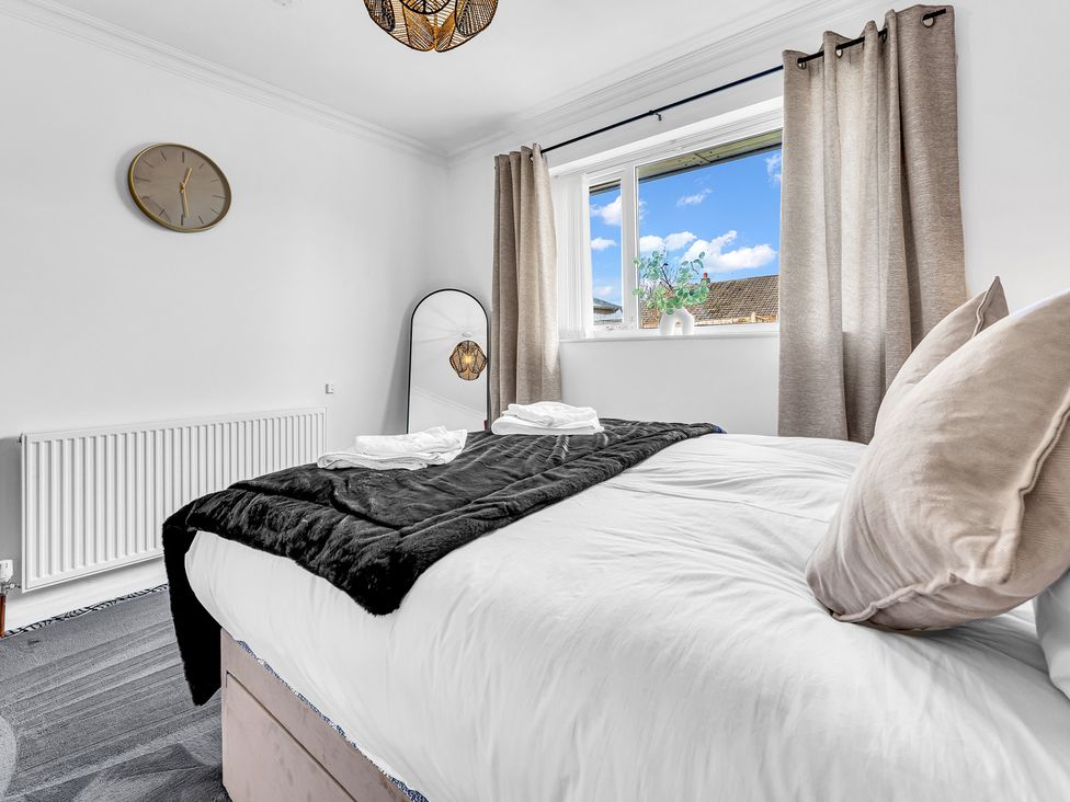 A bedroom with a bed and window at Mallory House in Stoke-on-Trent