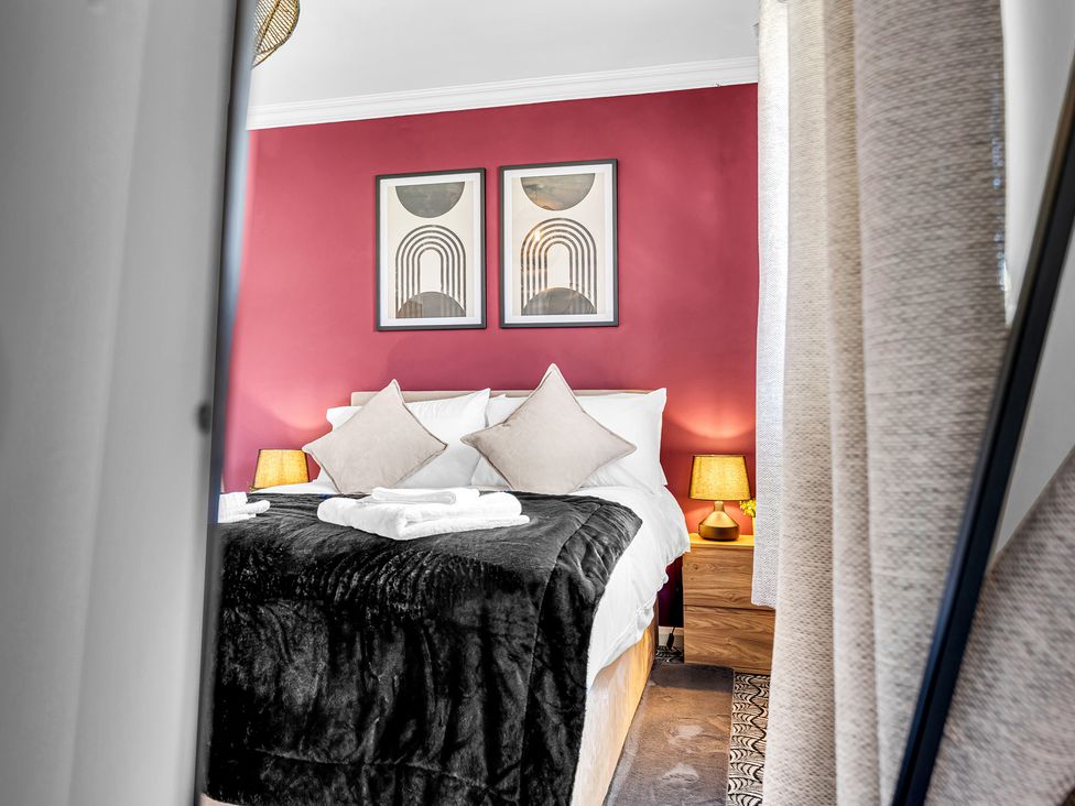 A bedroom with a bed and artwork on the wall at Mallory House in Stoke-on-Trent
