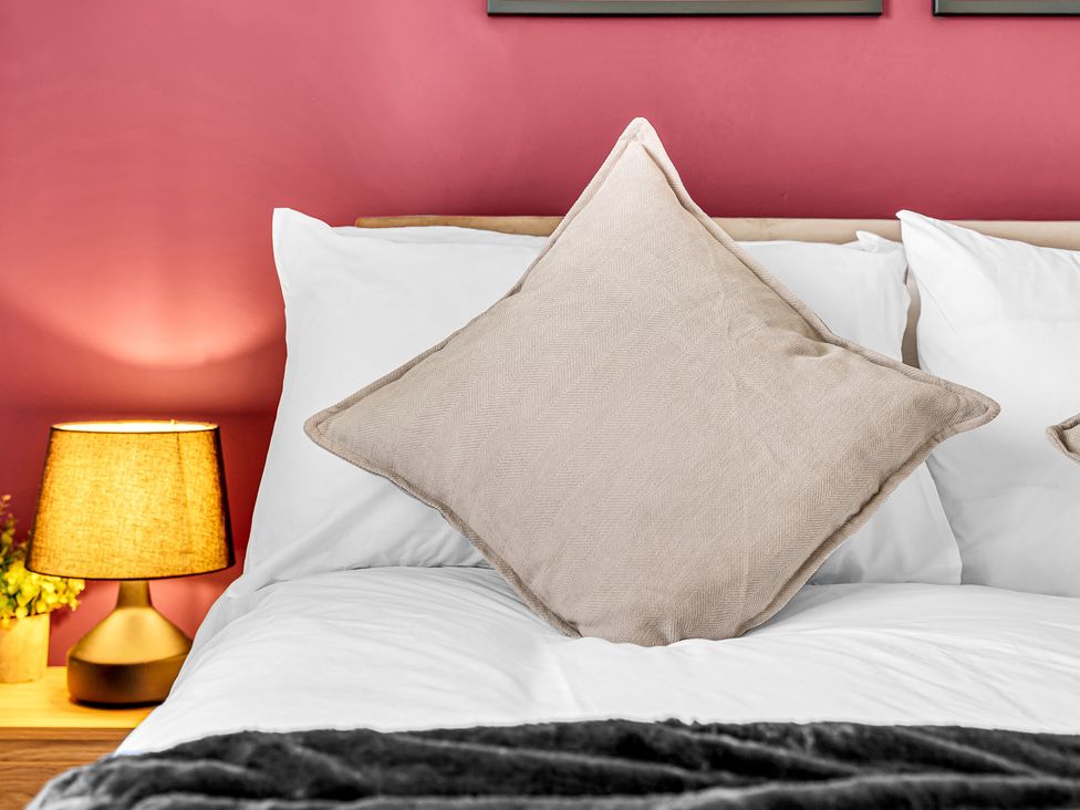 A bed with a pillow and lamp at Mallory House in Stoke-on-Trent