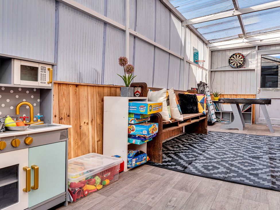 A playroom with a toy kitchen and bench at Mallory House in Stoke-on-Trent