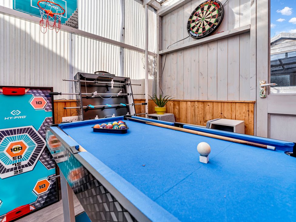 A games room with a pool table and dartboard at Mallory House in Stoke-on-Trent