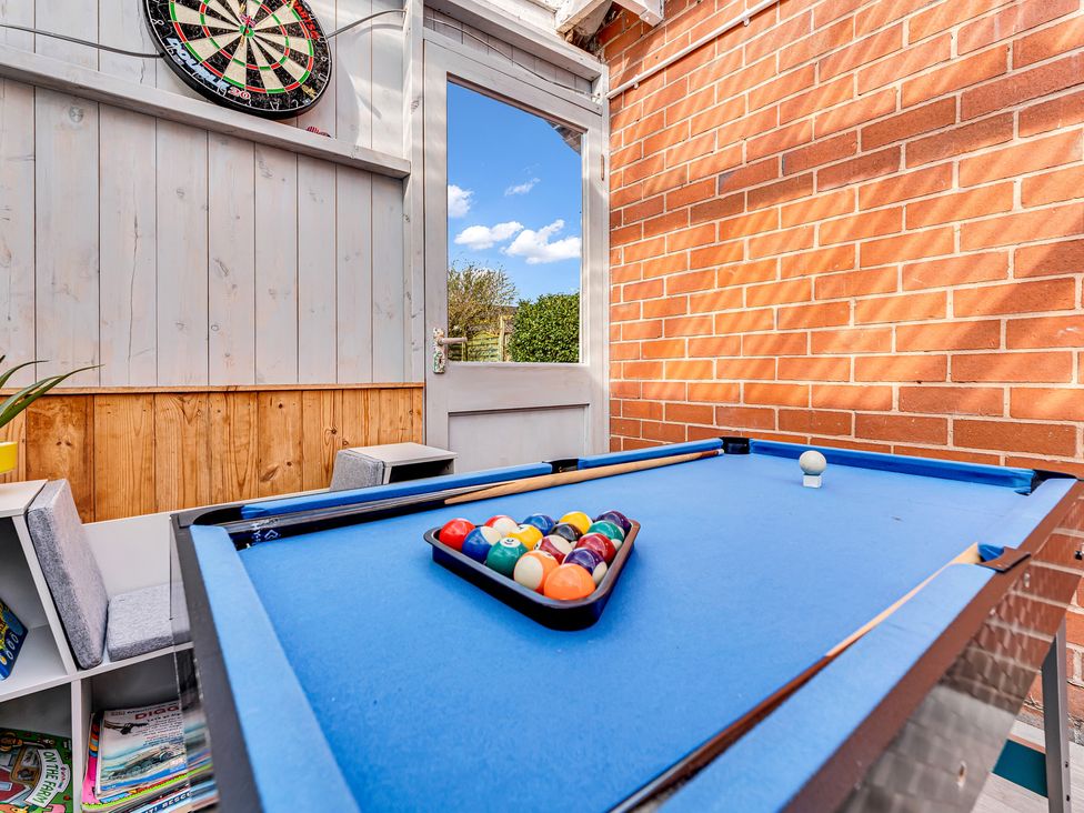A pool table with balls and a dartboard at Mallory House in Stoke-on-Trent