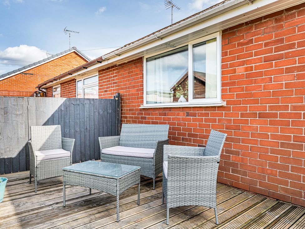 An outdoor seating set on a deck in front of a brick wall at Mallory House Stoke-on-Trent