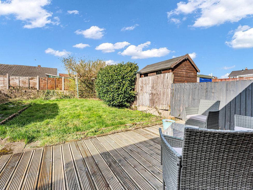 A garden with decking chairs and a shed at Mallory House Stoke-on-Trent