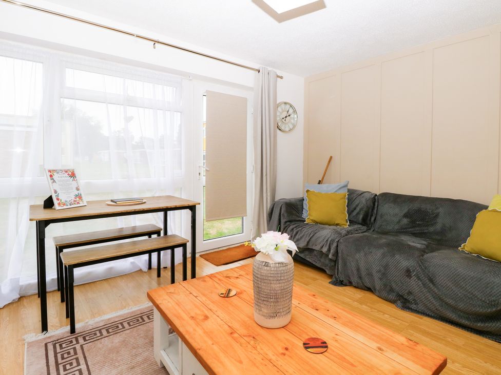 A living room with a sofa and table at Leaf Lodge in Hemsby