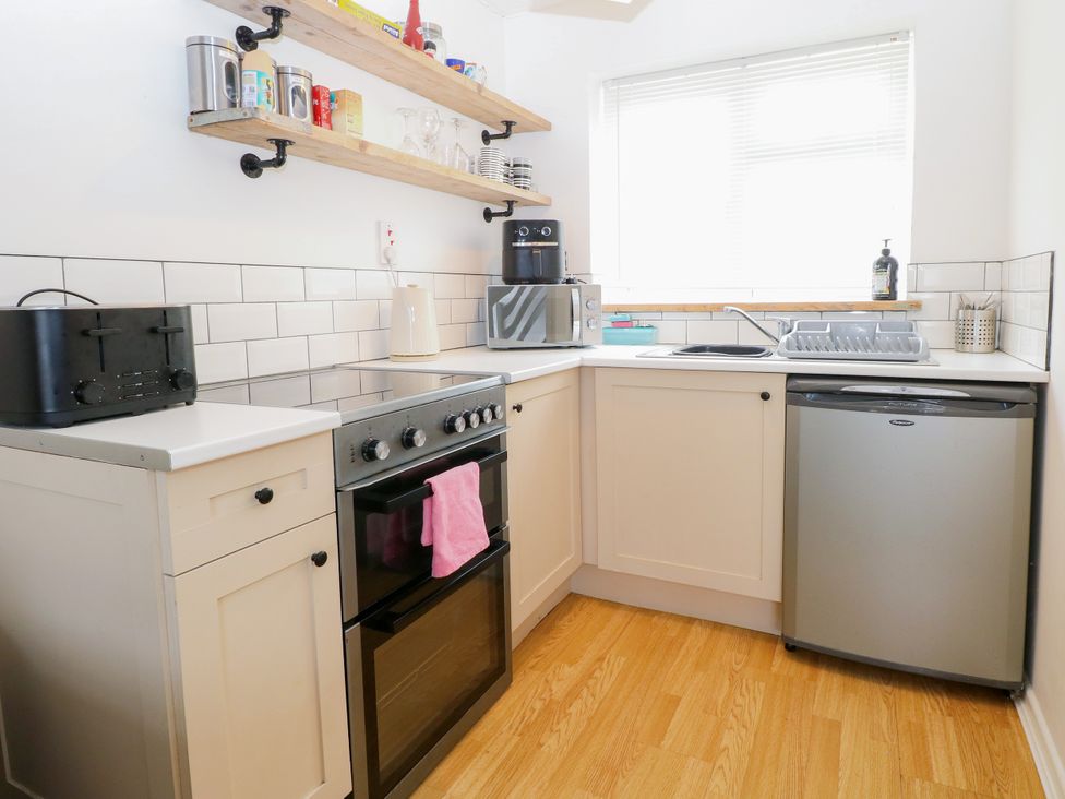 A kitchen with an oven and sink at Leaf Lodge in Hemsby