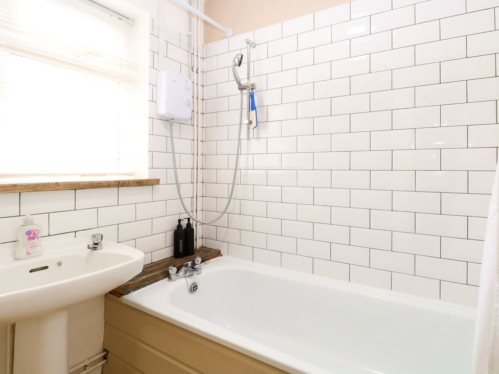 A bathroom featuring a sink and a bathtub at Leaf Lodge in Hemsby