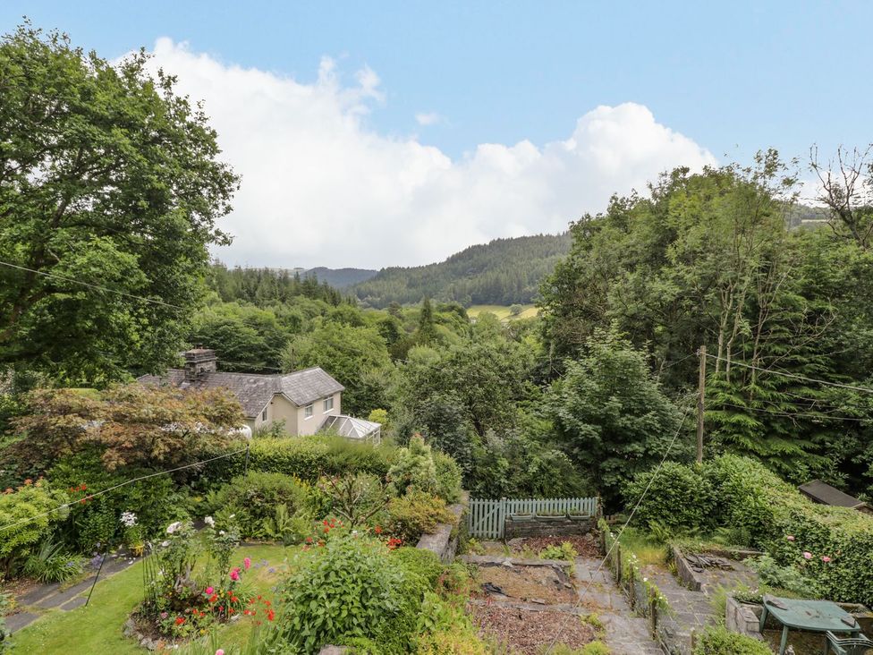 A garden with flowers and trees overlooking mountains at Awelfryn in Betws-y-Coed