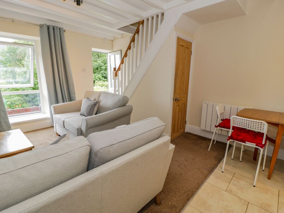 A living room with a sofa, a table and a window at Awelfryn in Betws-y-Coed