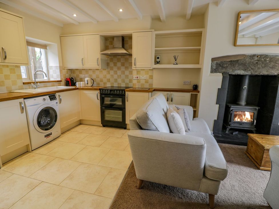 A kitchen with appliances and a sofa at Awelfryn in Betws-y-Coed