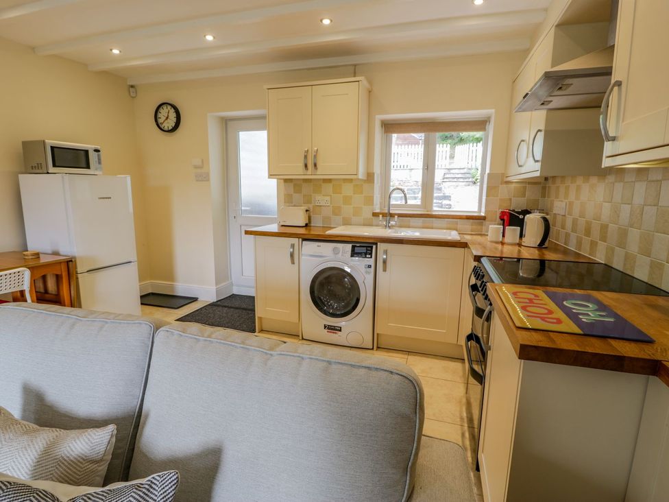 A kitchen with appliances and seating at Awelfryn in Betws-y-Coed