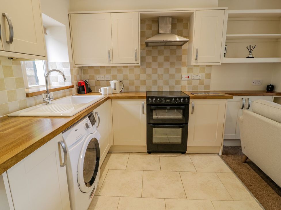 A kitchen with an oven and washing machine at Awelfryn in Betws-y-Coed