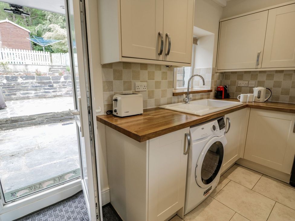 A kitchen with a washing machine and toaster at Awelfryn in Betws-y-Coed