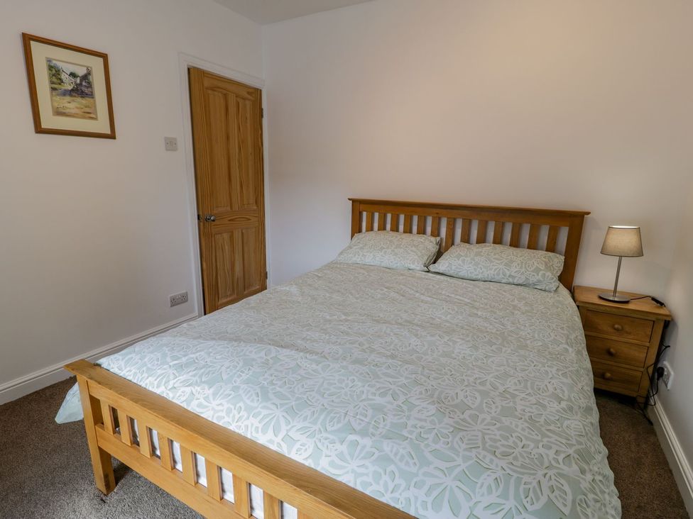 A bedroom with a bed and nightstand at Awelfryn in Betws-y-Coed