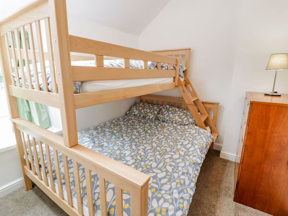 A bunk bed with a double bed in a bedroom at Awelfryn in Betws-y-Coed