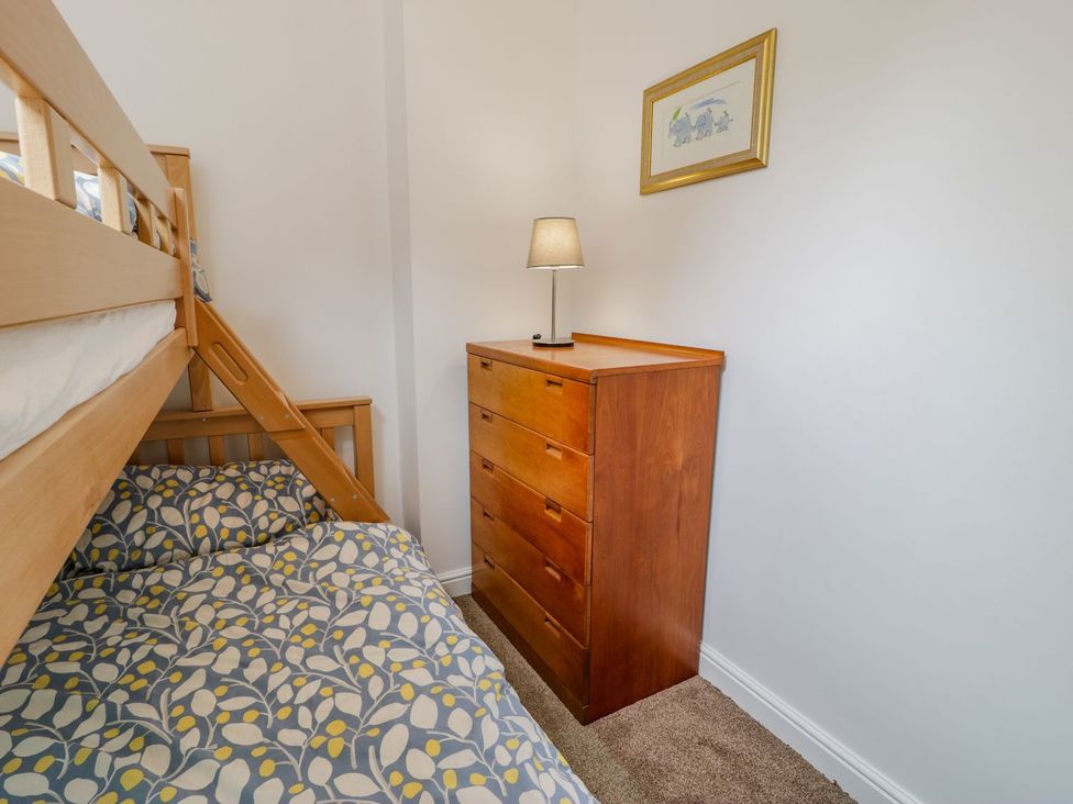 A bedroom with a bunk bed and a dresser at Awelfryn in Betws-y-Coed