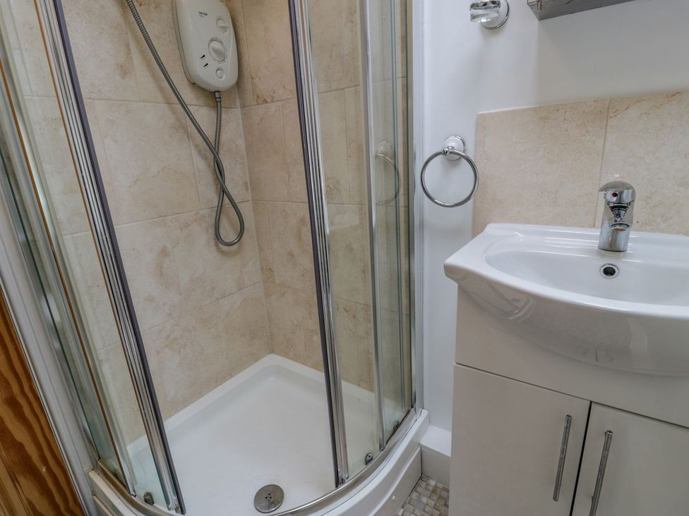 A bathroom with a shower and sink at Awelfryn in Betws-y-Coed