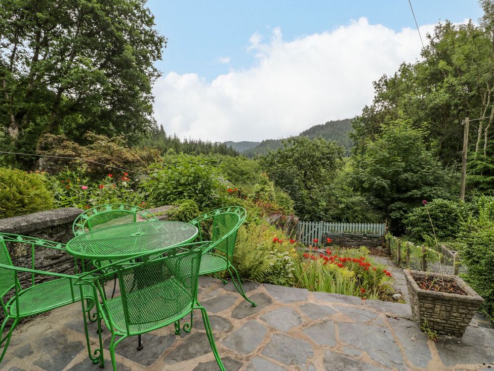 A garden with green table and chairs at Awelfryn in Betws-y-Coed