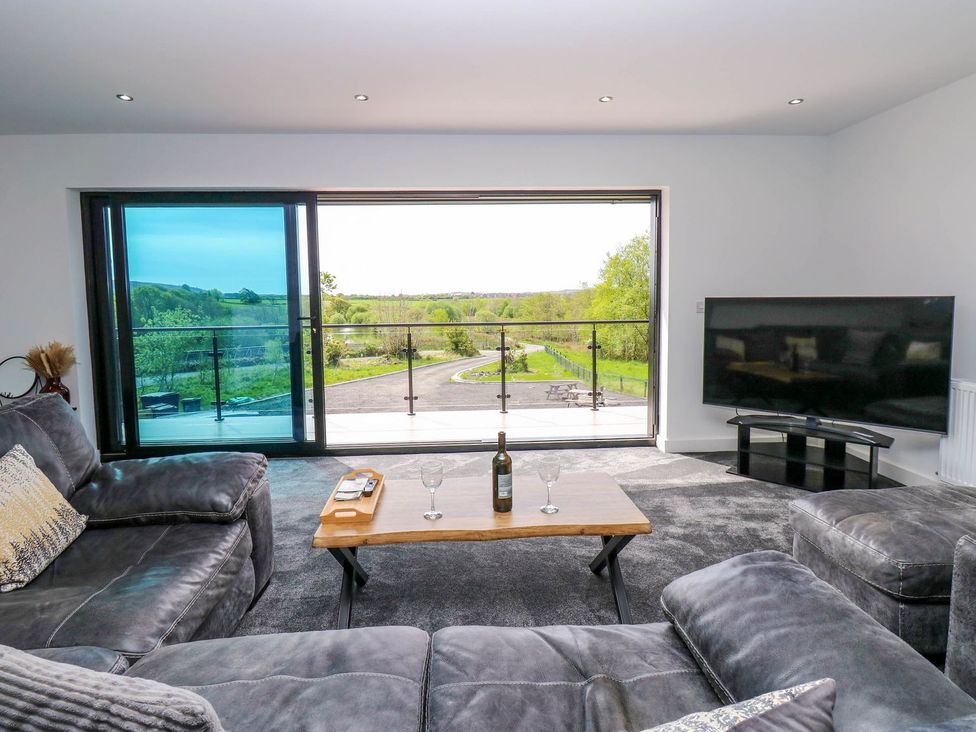 A living room with a sofa and television at Sycamore Cottage Frizington