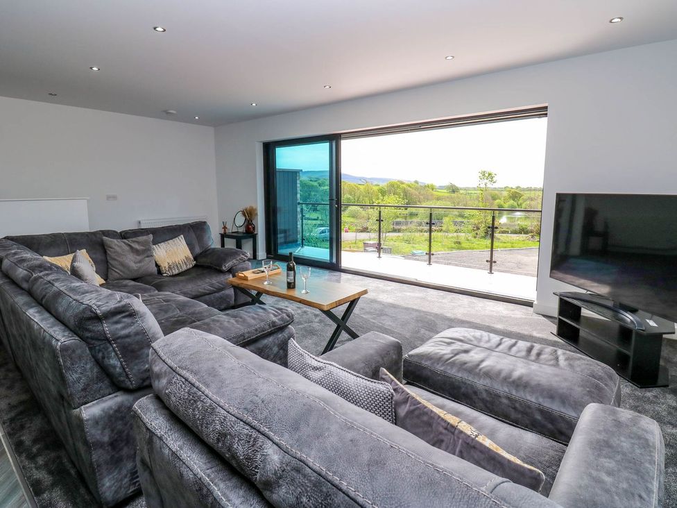 A living room with a sofa and television at Sycamore Cottage in Frizington