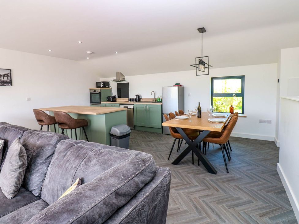 A kitchen and dining area with a sofa and dining table at Sycamore Cottage in Frizington