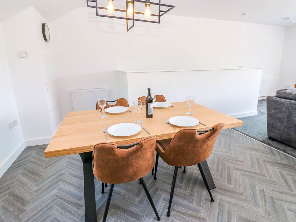 A dining room with a table set for four at Sycamore Cottage in Frizington