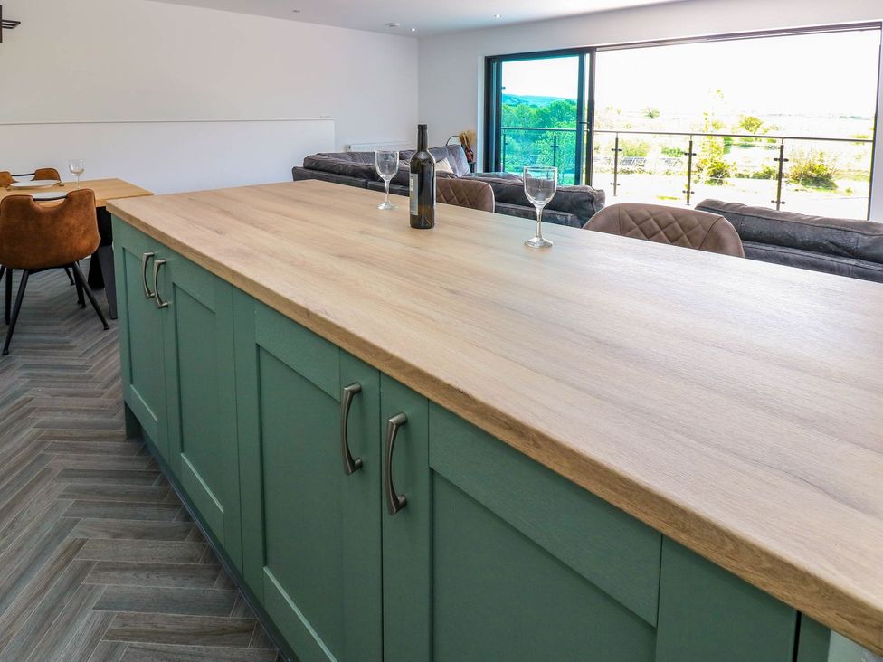 A kitchen with an island and dining area at Sycamore Cottage in Frizington