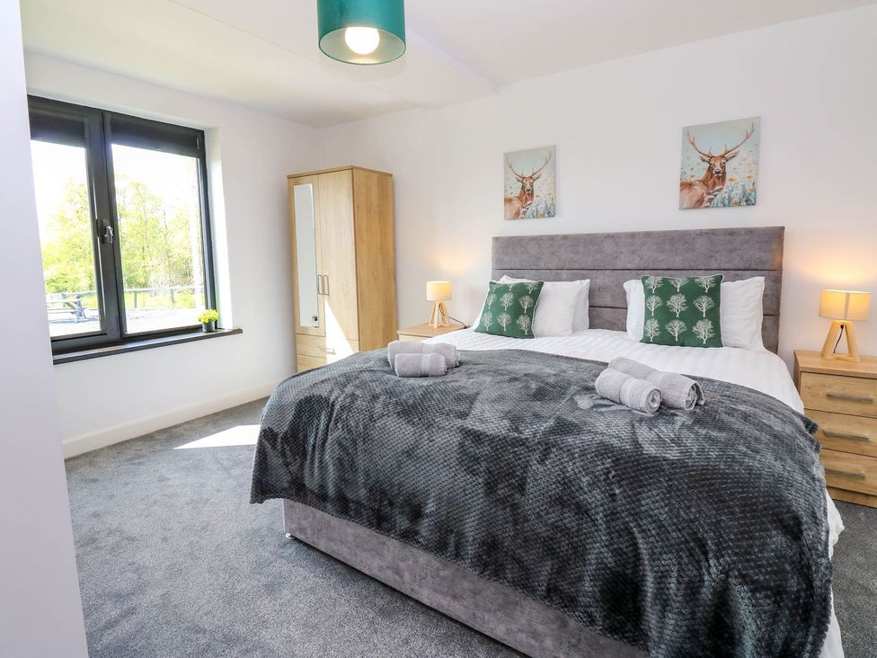 A bedroom with a bed and wardrobe at Sycamore Cottage in Frizington