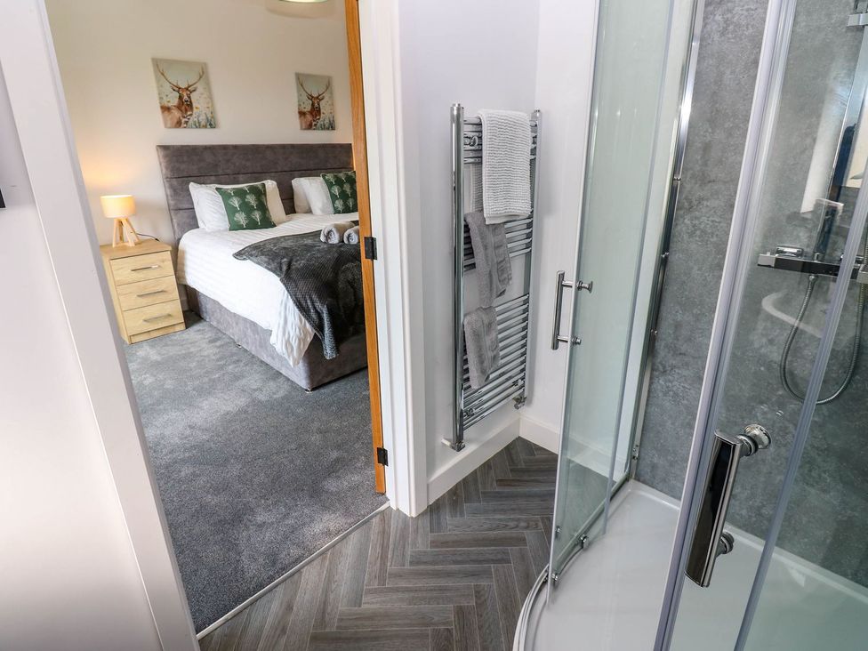 A bathroom with a shower and adjoining bedroom at Sycamore Cottage Frizington