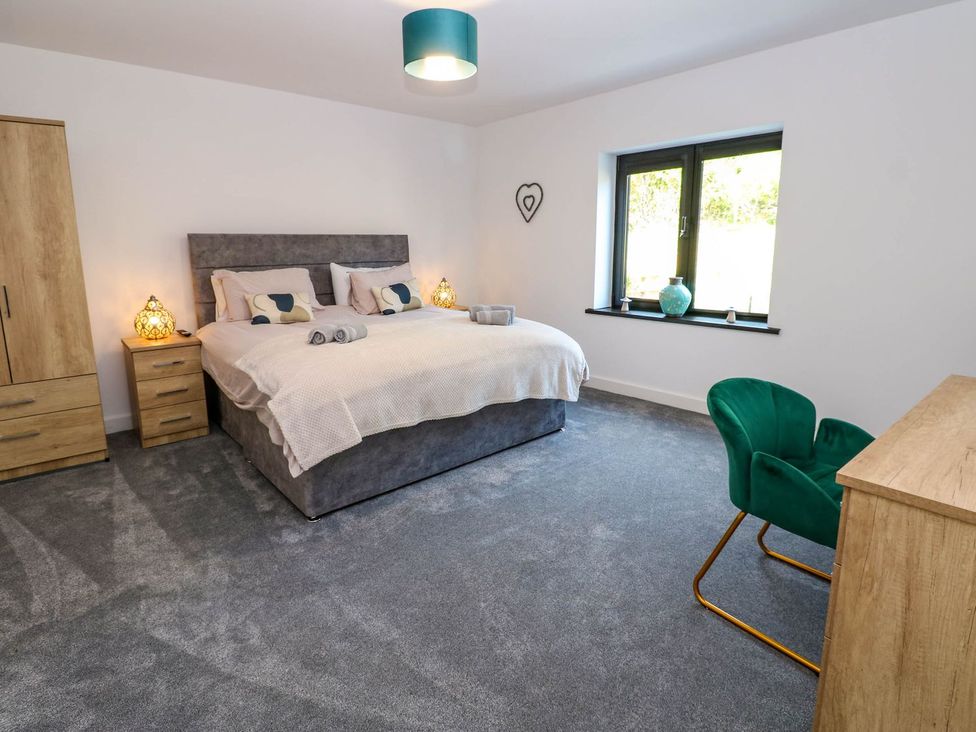 A bedroom with a bed and dresser at Sycamore Cottage in Frizington