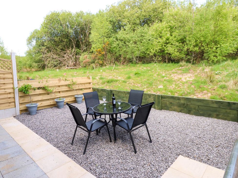 A garden with a table and chairs at Sycamore Cottage in Frizington