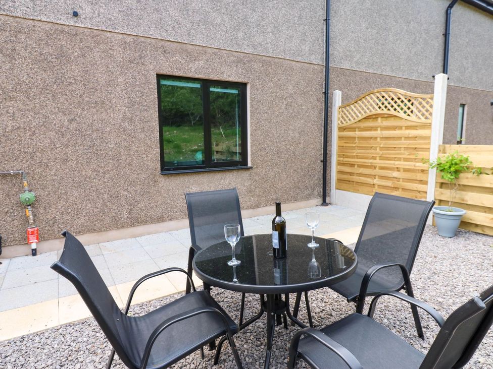 A patio area with a table and chairs at Sycamore Cottage in Frizington