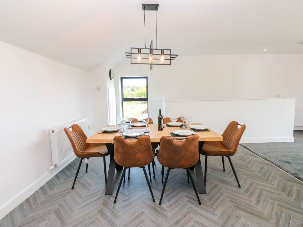 A dining room with a table and chairs at Silver Birch Cottage Frizington