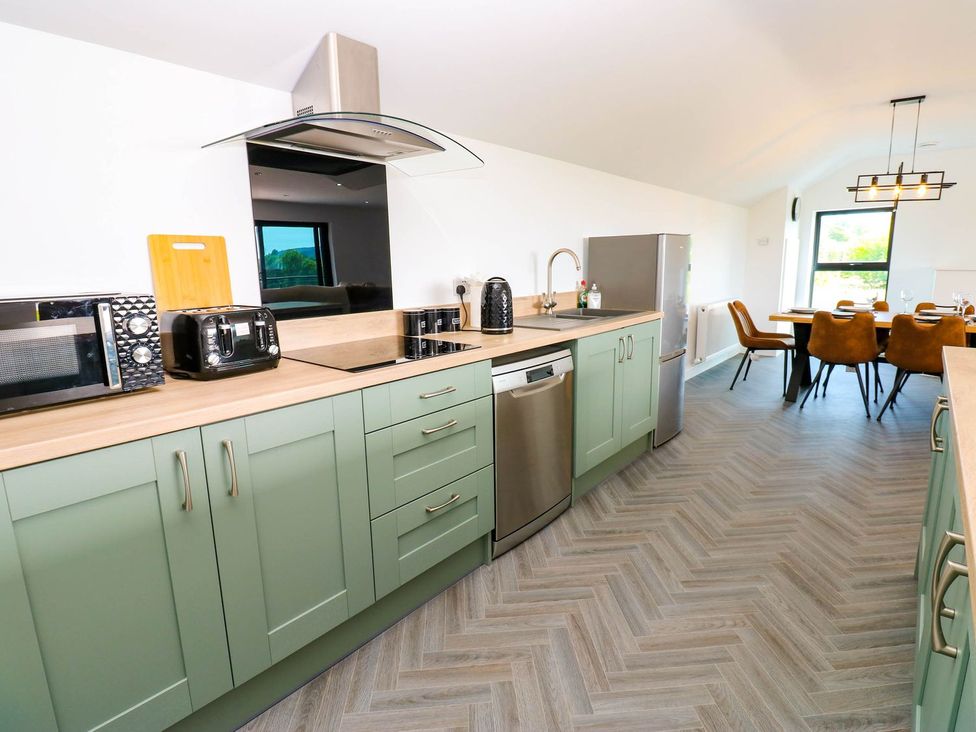 A kitchen with cabinets and appliances at Silver Birch Cottage in Frizington