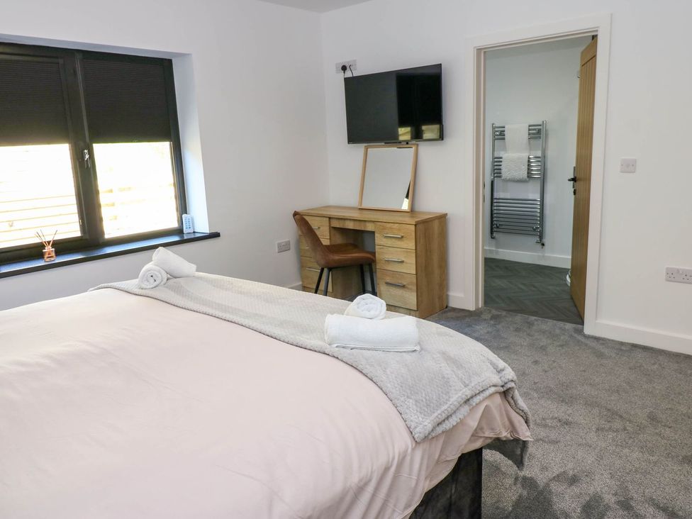 A bedroom with a bed and a desk at Silver Birch Cottage in Frizington