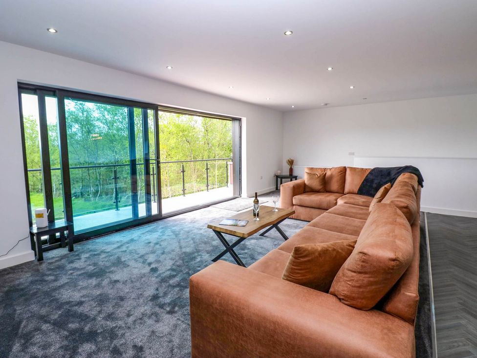 A living room with a sofa and sliding doors at Oak Tree Cottage in Frizington