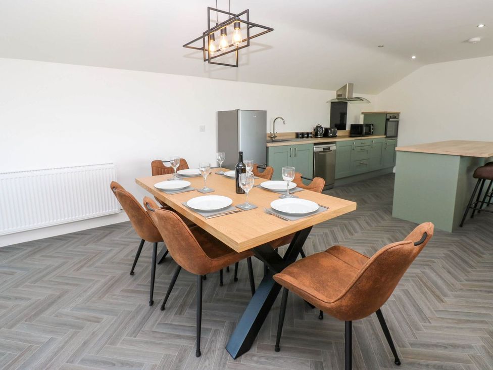 A dining room with a table and chairs at Oak Tree Cottage in Frizington