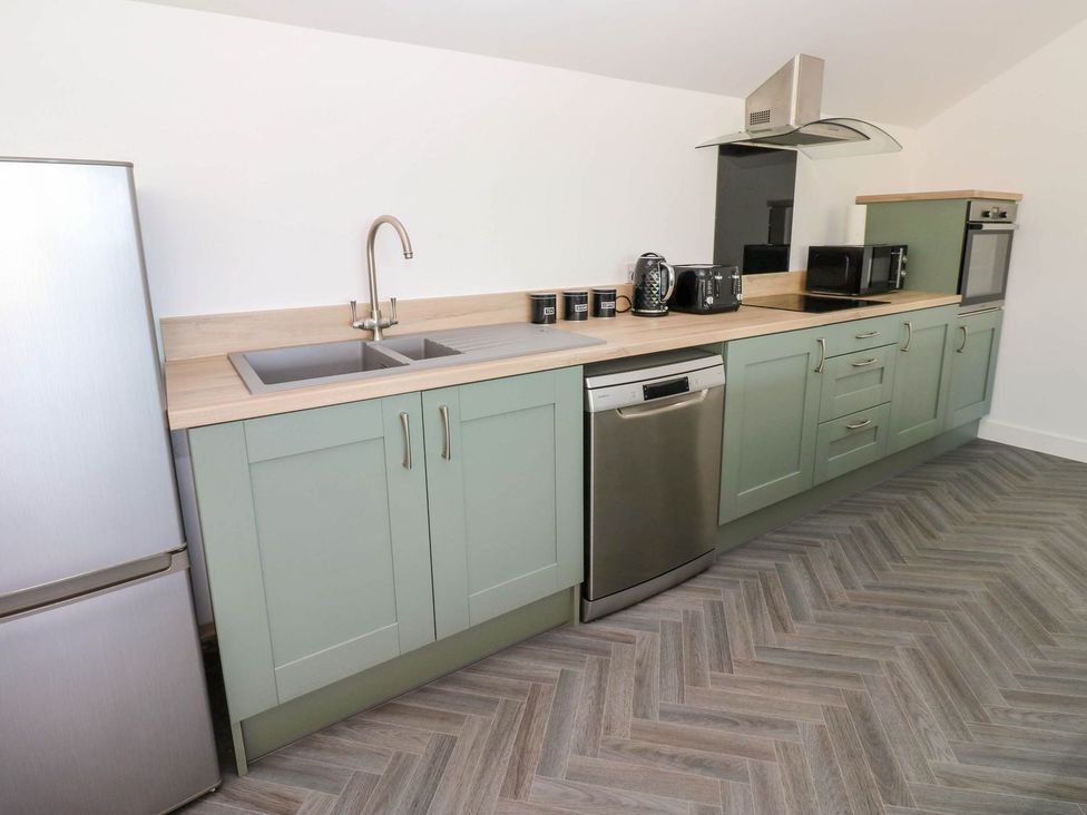 A kitchen with cabinets and appliances at Oak Tree Cottage in Frizington